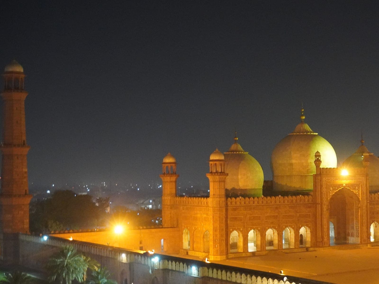 A night view of the red sandstone facade and domes of Badshahi Mosque in Lahore